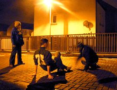 DR. BEAT Bboying / Breakdancing with young people in Wester Hailes on brick paving beside lit street light, fence and house at night